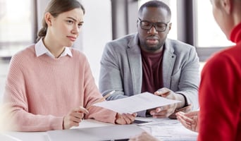 Confused Couple look over documents and are hesitant to bind