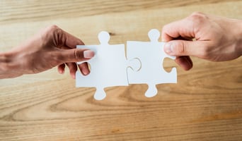cropped view of African American woman and man holding jigsaw puzzle pieces