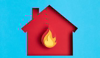 Papercut house with fire inside.