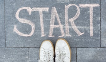 standing legs on sidewalk in front of word hand written chalk start