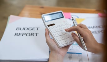 Woman reviewing budget report and using calculator