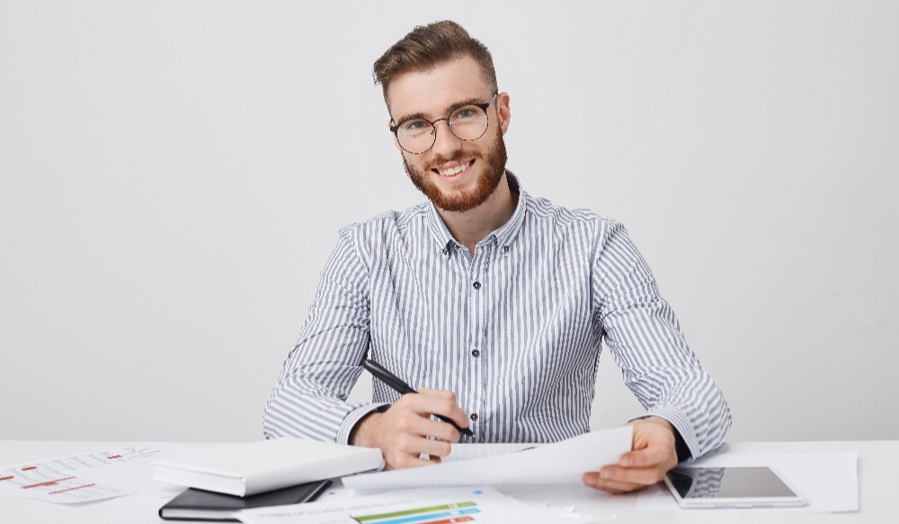 Busy, smiling bearded male entrepreneur