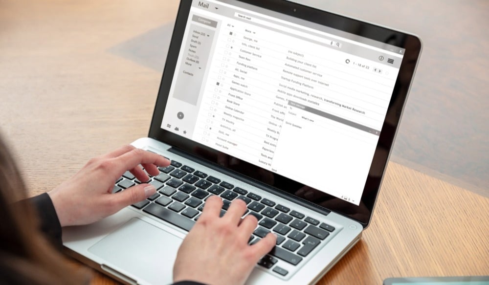 Email client list, woman hand on the computer laptop, inbox e mail message on the screen, close up