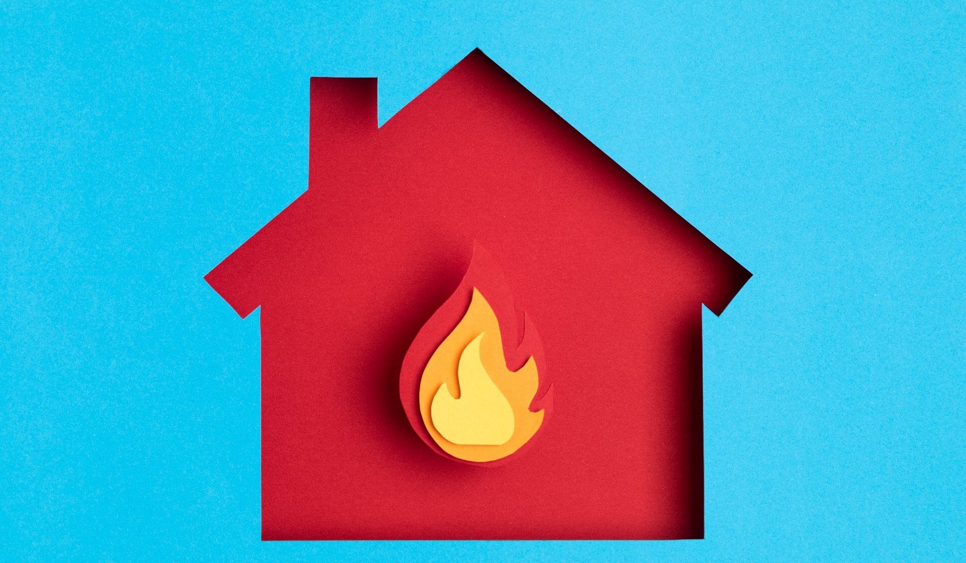 Papercut house with fire inside.