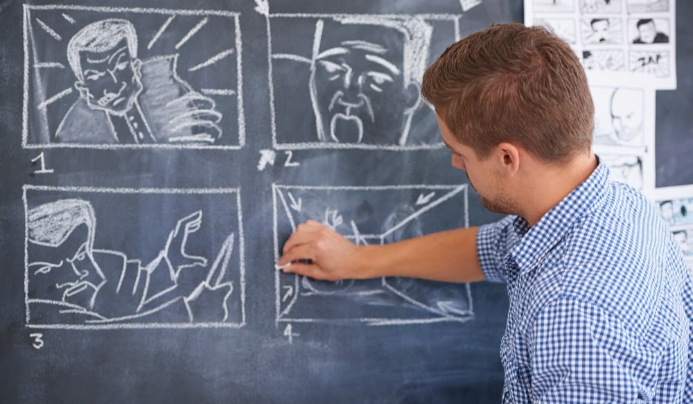 Planning for his next shoot. A young man drawing up a storyboard on his office chalkboard