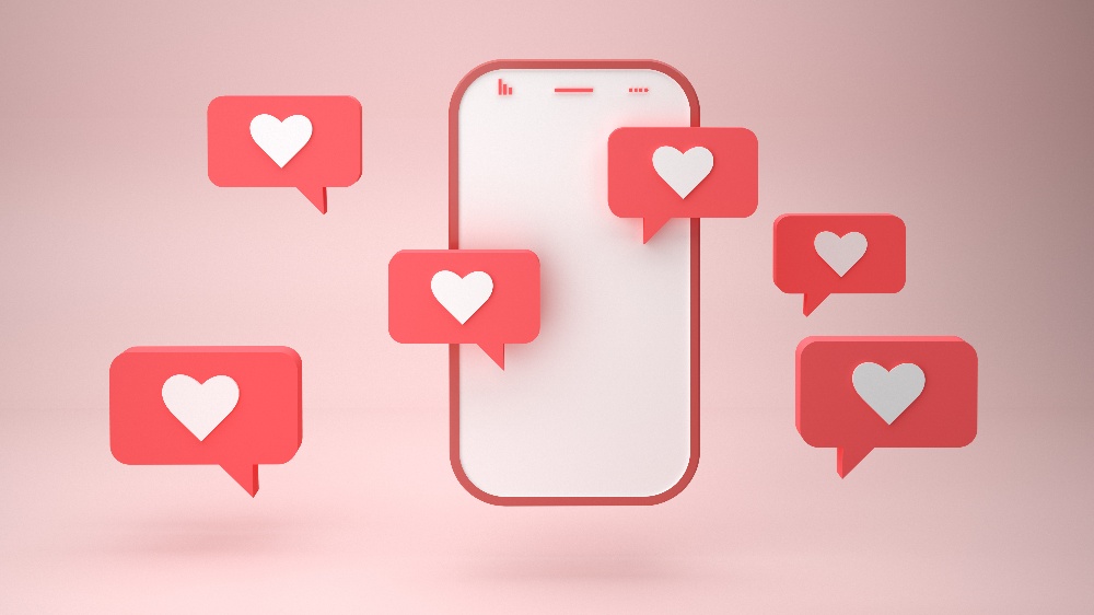 Smartphone and heart sign notification bubbles on pink background 